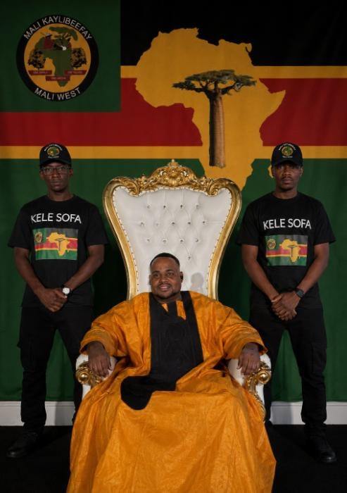 Mansa Sundiata Keita Kamara seated on the ceremonial throne with Kele Sofa guards and the Mali Kaylibeefay flag